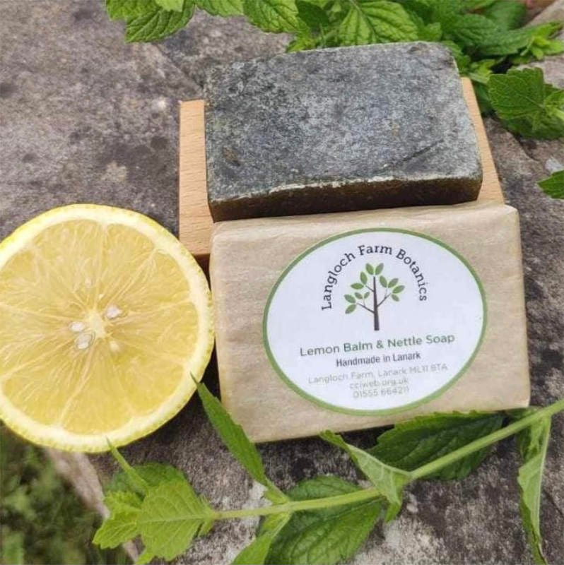 A photo of a wax wrapped bar of soap with lemon slice and nettle stem